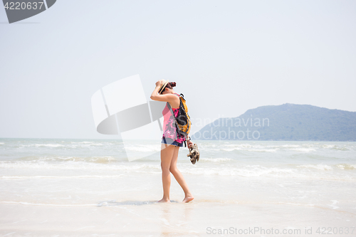 Image of Woman with sandals in arms