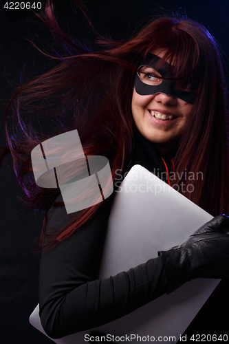 Image of Girl in mask holds laptop