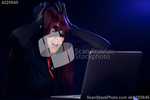 Image of Surprised thief next to laptop