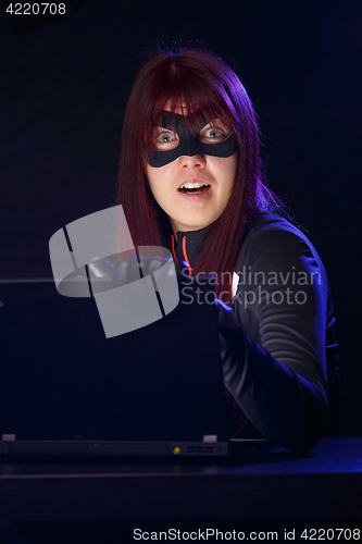 Image of Brunette stealing information from laptop