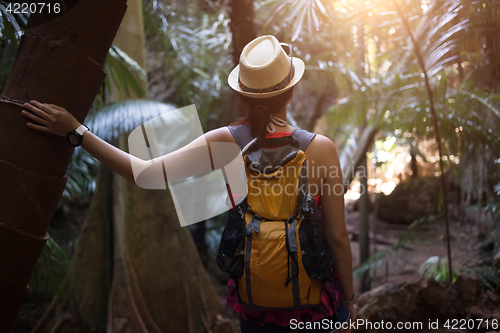 Image of Girl in hat among palms