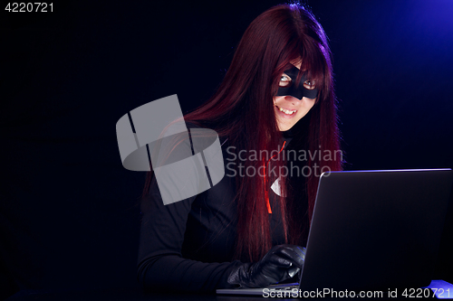 Image of Smiling brunette thief with laptop