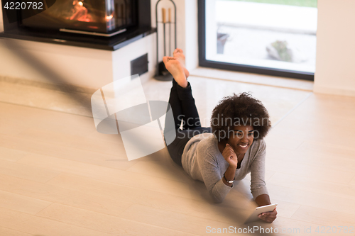 Image of black women using tablet computer on the floor