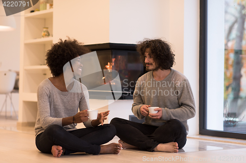 Image of multiethnic couple  in front of fireplace