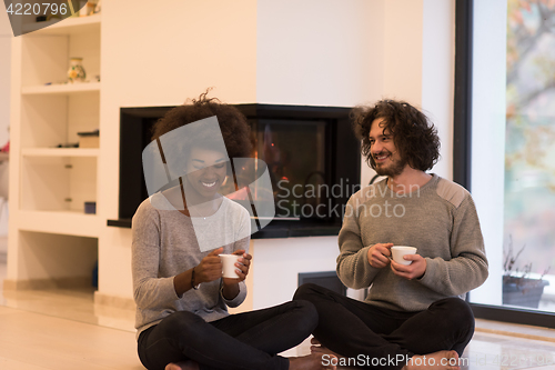 Image of multiethnic couple  in front of fireplace