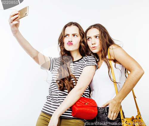 Image of lifestyle people concept: two pretty stylish modern hipster teen girl having fun together, happy smiling making selfie