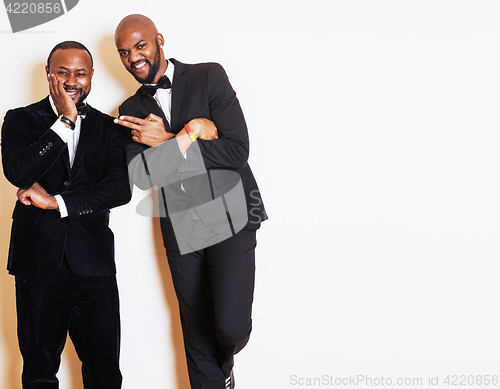 Image of two afro-american businessmen in black suits emotional posing, gesturing, smiling. wearing bow-ties 