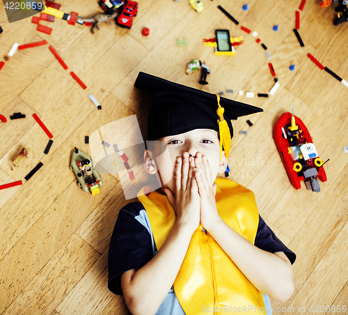 Image of little cute preschooler boy among toys lego at home education in graduate hat smiling posing emotional, lifestyle people concept