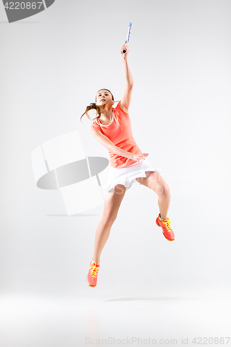 Image of Young woman playing badminton over white background