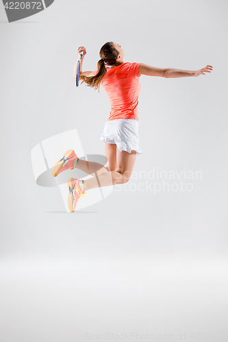 Image of Young woman playing badminton over white background