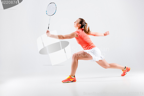 Image of Young woman playing badminton over white background