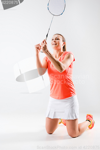 Image of Young woman playing badminton over white background