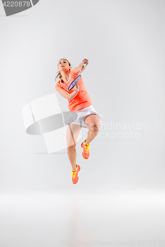 Image of Young woman playing badminton over white background