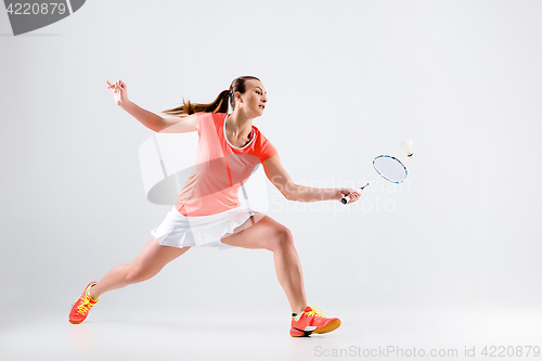 Image of Young woman playing badminton over white background