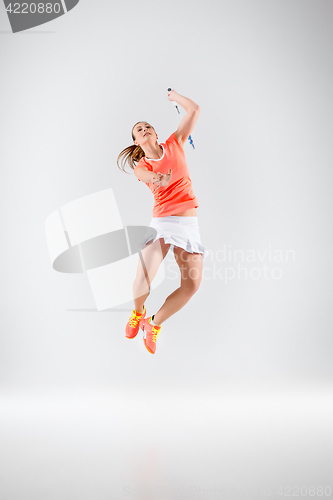 Image of Young woman playing badminton over white background