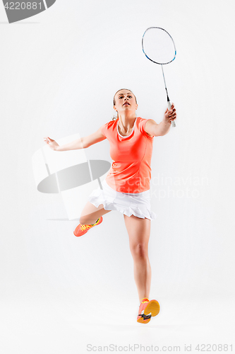 Image of Young woman playing badminton over white background