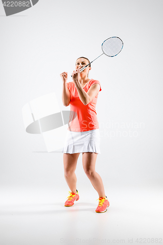 Image of Young woman playing badminton over white background