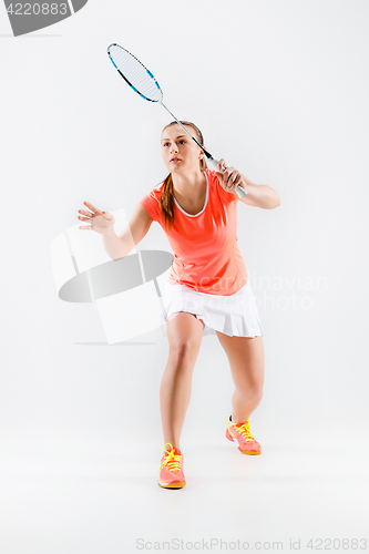 Image of Young woman playing badminton over white background