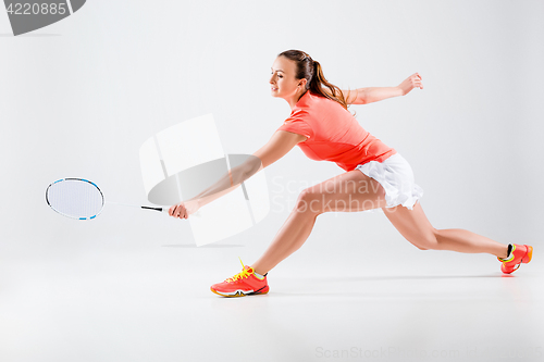 Image of Young woman playing badminton over white background