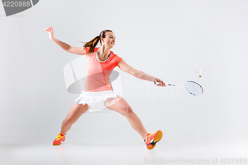 Image of Young woman playing badminton over white background