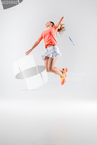 Image of Young woman playing badminton over white background