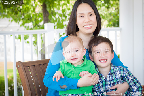 Image of Outdoor Portrait of A Chinese Mother with Her Two Mixed Race Chi