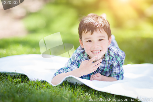 Image of Mixed Race Chinese and Caucasian Young Boy Relaxing Outside On T