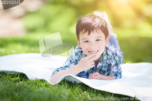 Image of Mixed Race Chinese and Caucasian Young Boy Relaxing Outside On T