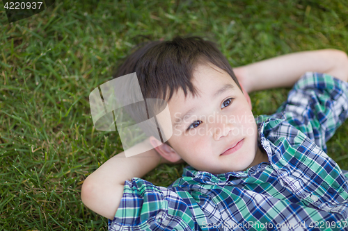 Image of Thoughtful Mixed Race Chinese and Caucasian Young Boy Relaxing O