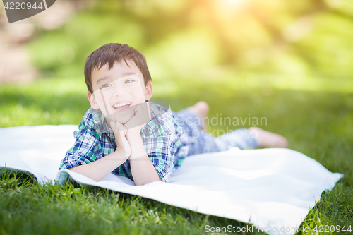 Image of Mixed Race Chinese and Caucasian Young Boy Relaxing Outside On T