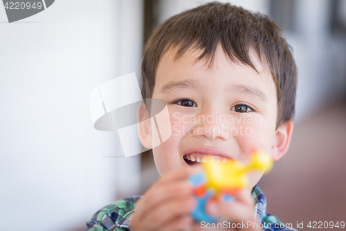 Image of Portrait of Mixed Race Chinese and Caucasian Young Boy With Toy