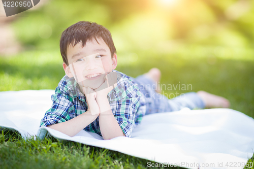 Image of Mixed Race Chinese and Caucasian Young Boy Relaxing Outside On T
