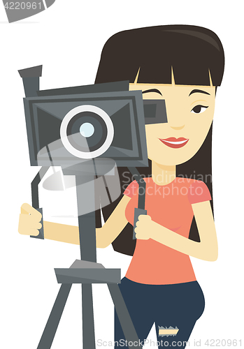 Image of Cameraman with movie camera on tripod.