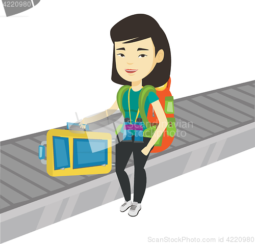 Image of Woman picking up suitcase on luggage conveyor belt