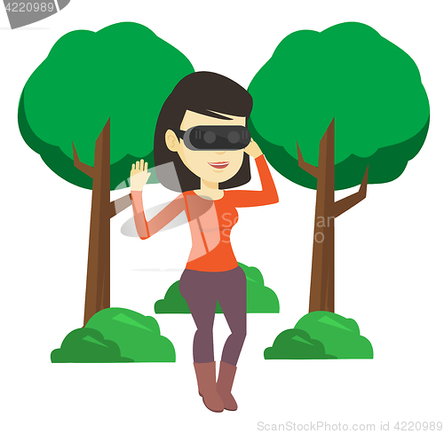 Image of Woman wearing virtual reality headset in the park.