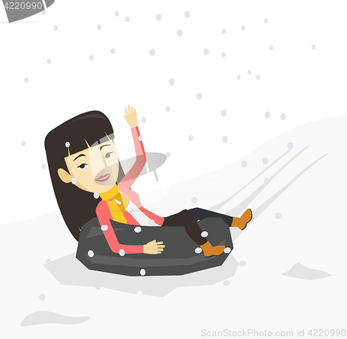 Image of Woman sledding on snow rubber tube in mountains.