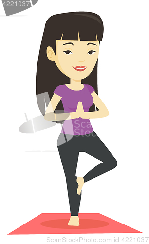Image of Young woman practicing yoga tree pose.