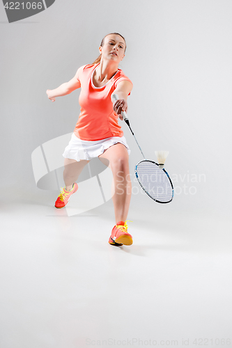 Image of Young woman playing badminton over white background