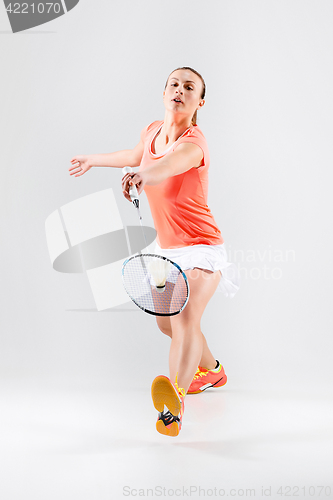 Image of Young woman playing badminton over white background