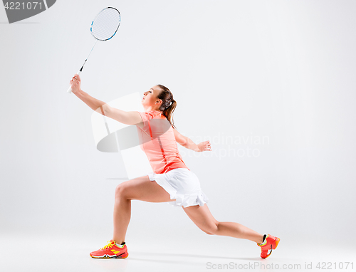 Image of Young woman playing badminton over white background