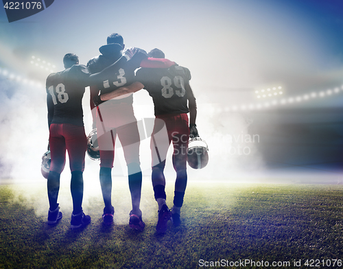 Image of The three american football players on on stadium background