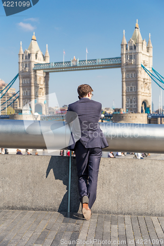 Image of British businessman talking on mobile phone outdoor in London city, UK.