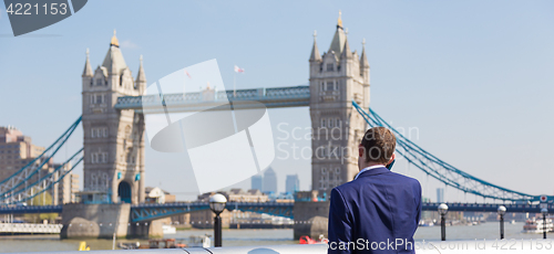 Image of British businessman talking on mobile phone outdoor in London city, UK.