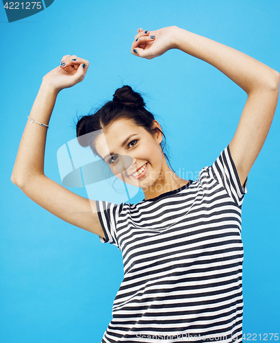 Image of young pretty teenage modern hipster girl posing emotional happy smiling on blue background, lifestyle people concept 