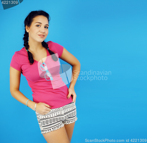 Image of young pretty teenage modern hipster girl posing emotional happy smiling on blue background, lifestyle people concept 
