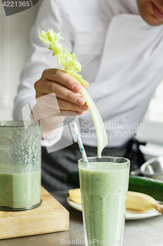 Image of Male chef serving glass with smoothie