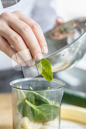 Image of Crop hands making fresh smoothie