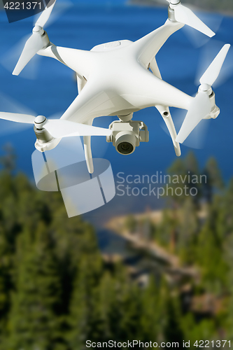 Image of Unmanned Aircraft System (UAV) Quadcopter Drone In The Air Over 