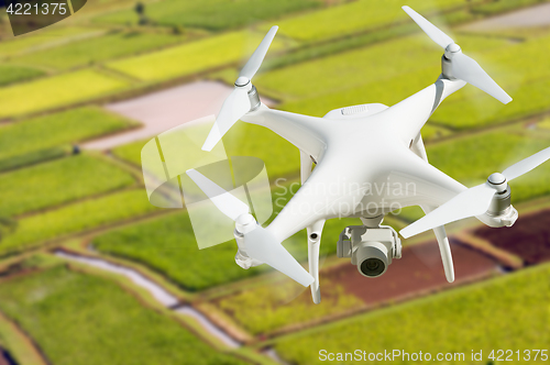 Image of Unmanned Aircraft System (UAV) Quadcopter Drone In The Air Over 