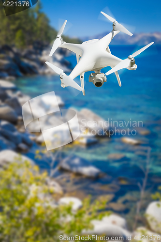 Image of Unmanned Aircraft System (UAV) Quadcopter Drone In The Air Over 